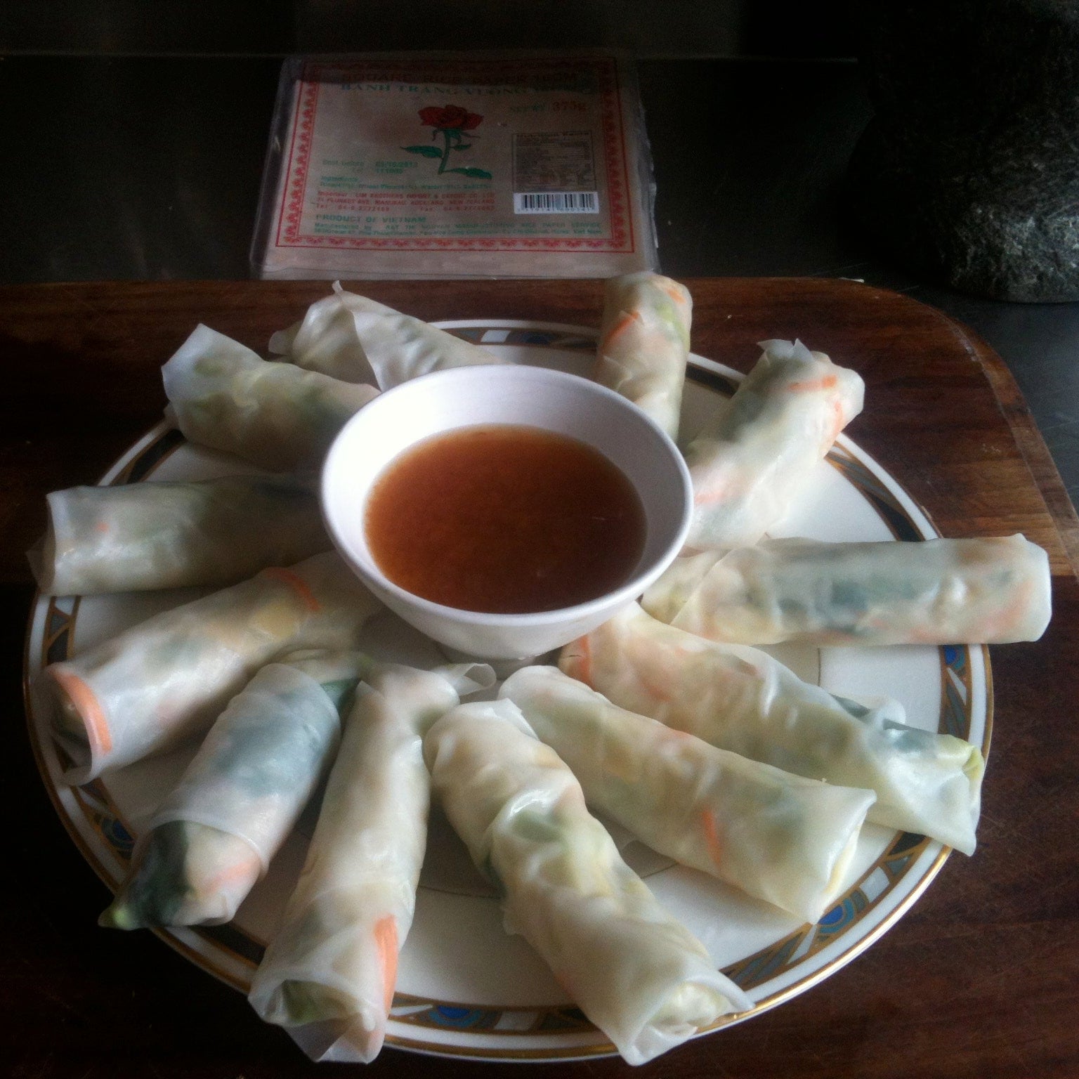 Spring rolls on a plate with dipping sauce on a wooden table