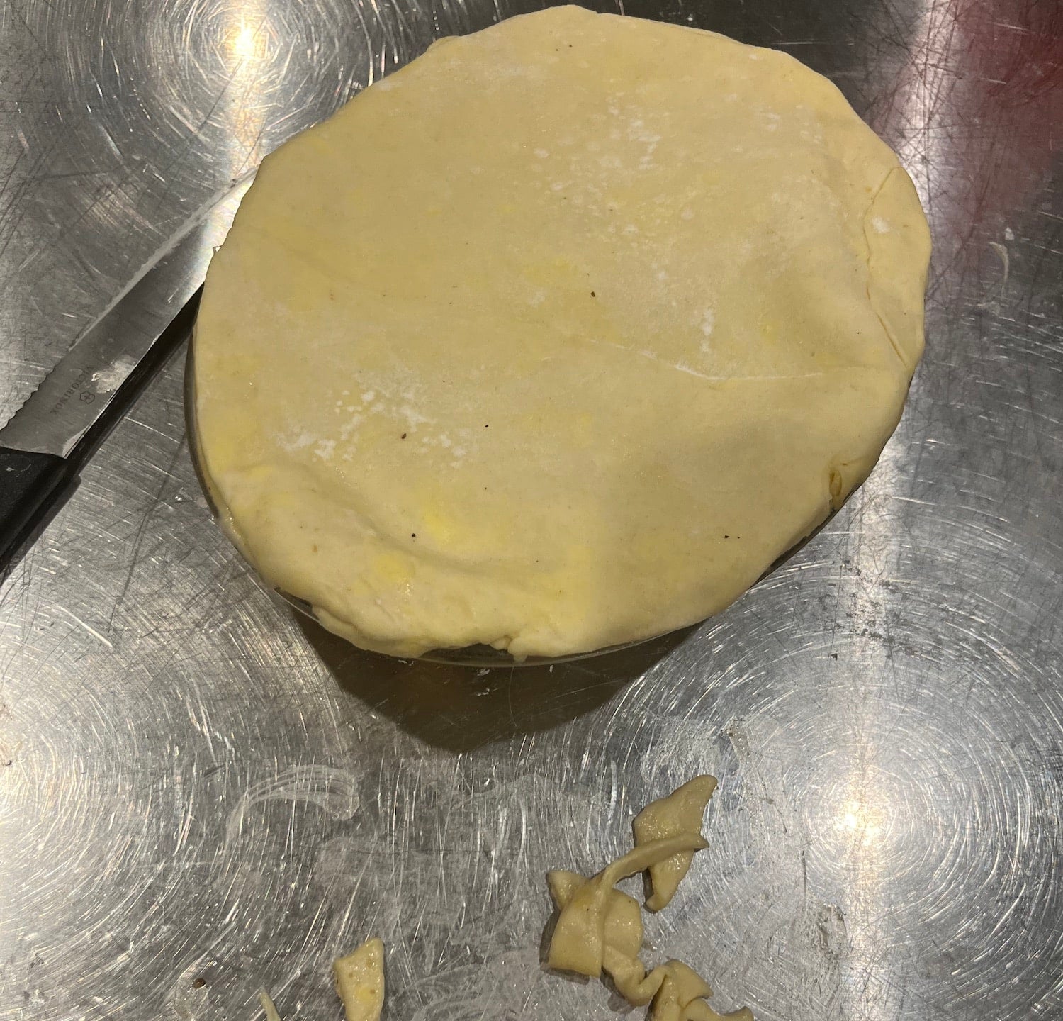 Ball of dough on a metal surface with a knife
